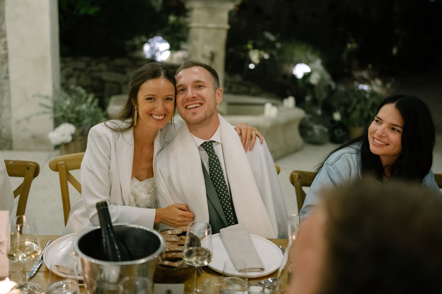 Outdoor wedding reception dinner setup with string lights creating a warm ambiance.