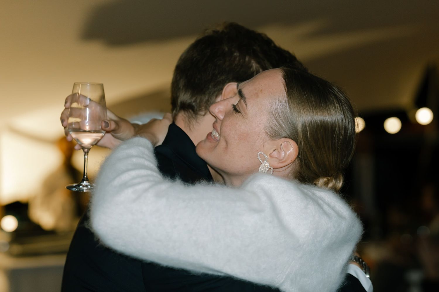 An intimate moment captured during a wedding reception as two people share an embrace.