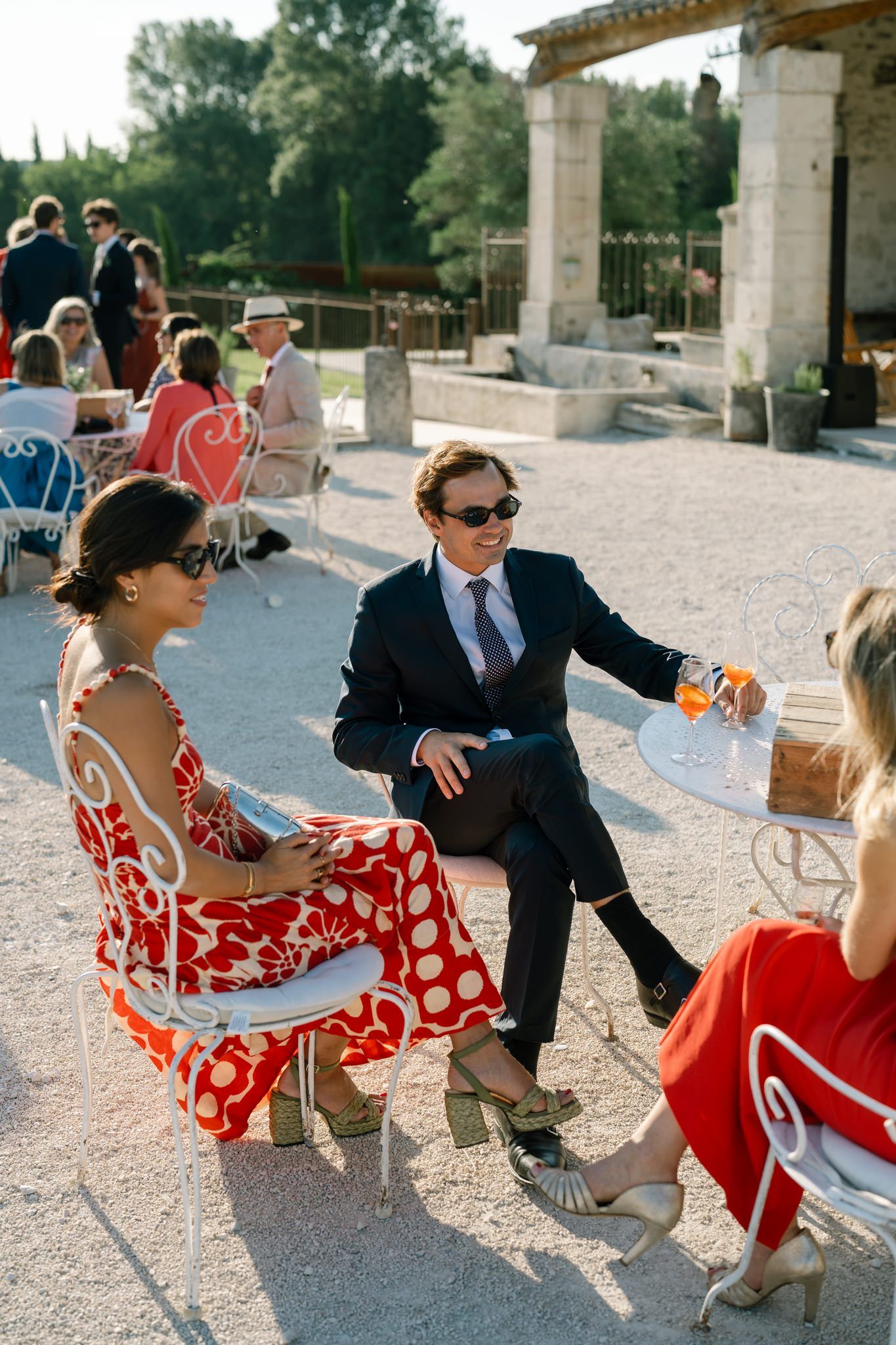 Wedding guests in formal attire dancing and celebrating on a stone patio.