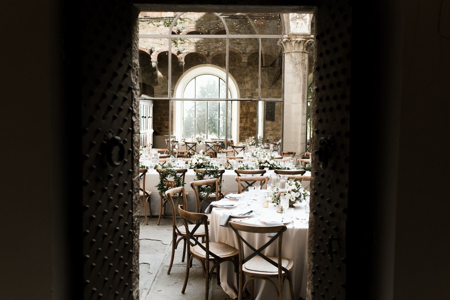 Elegant wedding reception tables set up in a rustic stone courtyard venue.
