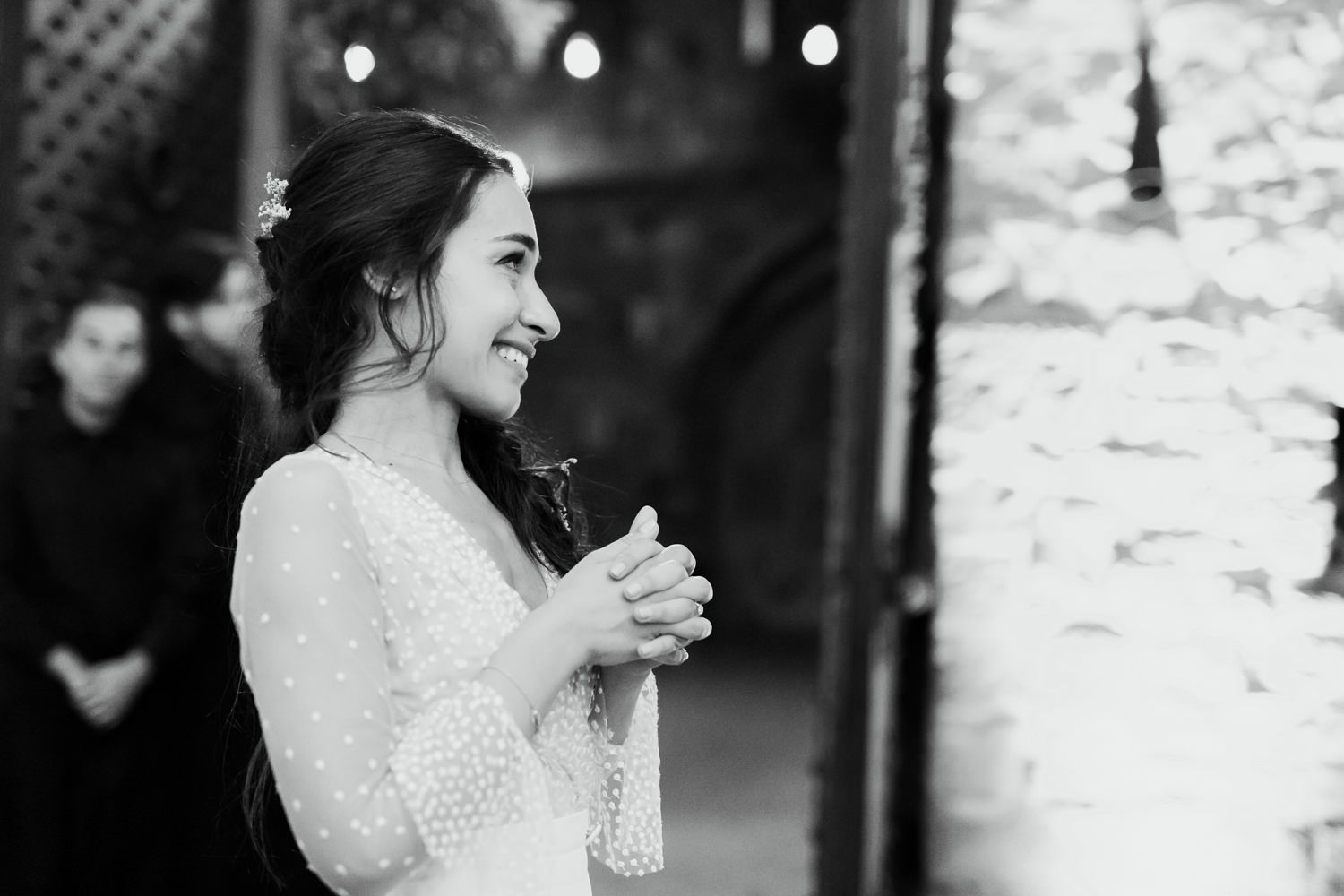 Wedding celebration in a historic stone-walled venue with romantic lighting and elegant table settings.
