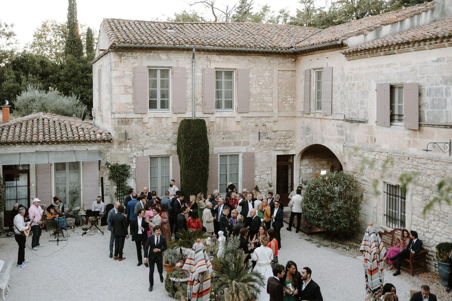 Stone exterior of an elegant French chateau venue with guests gathering outside.