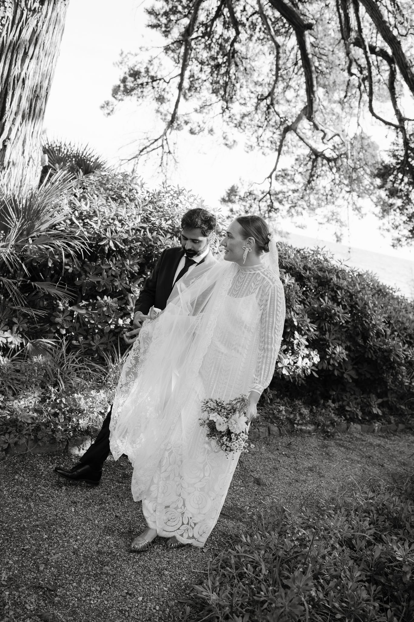 A flowing white dress twirls gracefully against a natural outdoor backdrop in black and white.