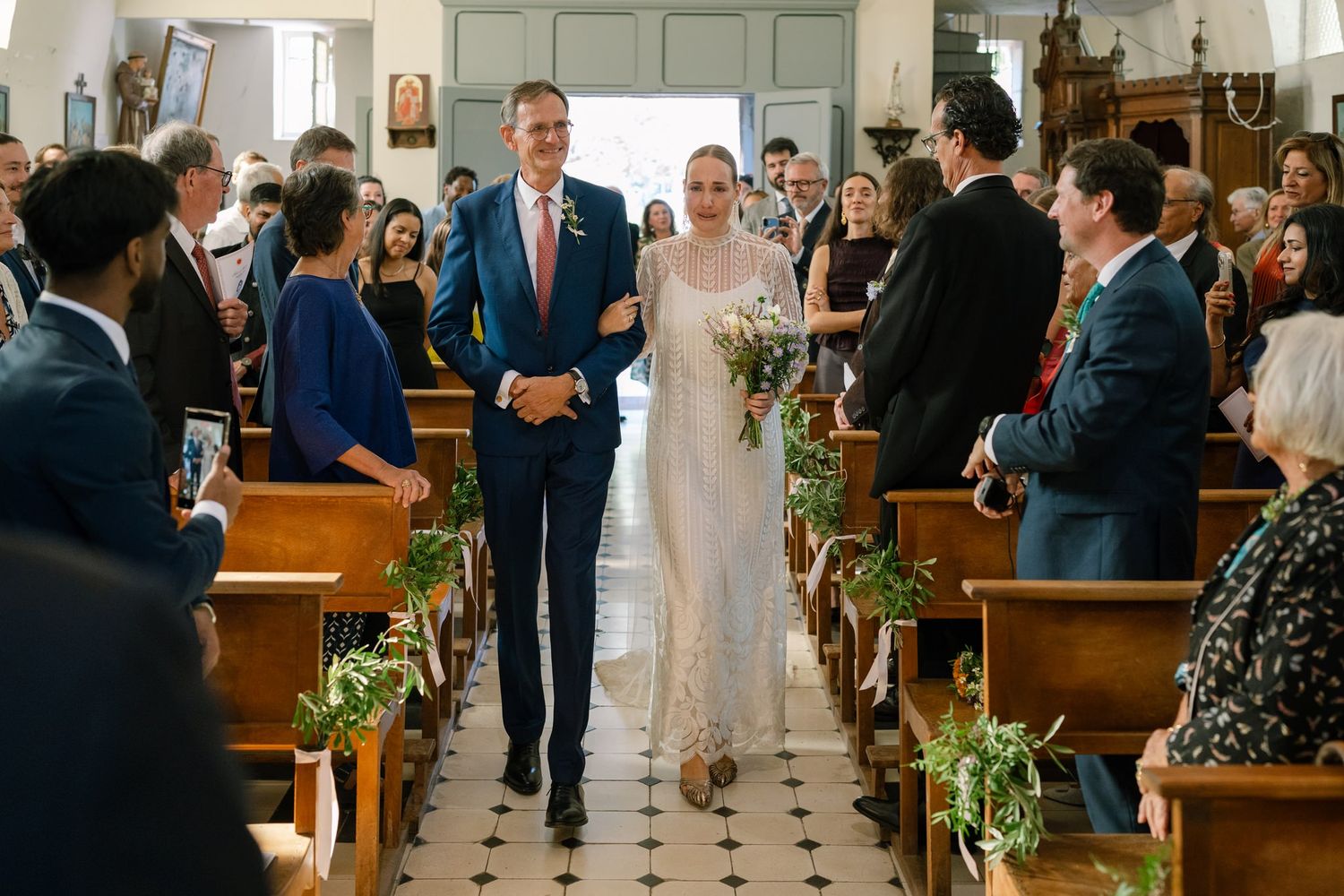 Wedding guests line the church aisle during a joyous ceremony celebration.