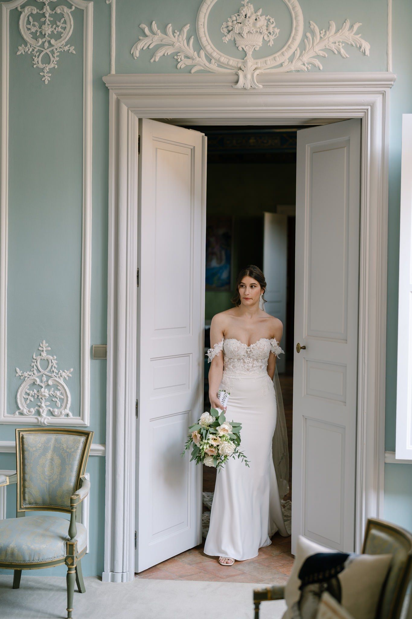 Elegant bridal portraits in a room with ornate mint green wall moldings.