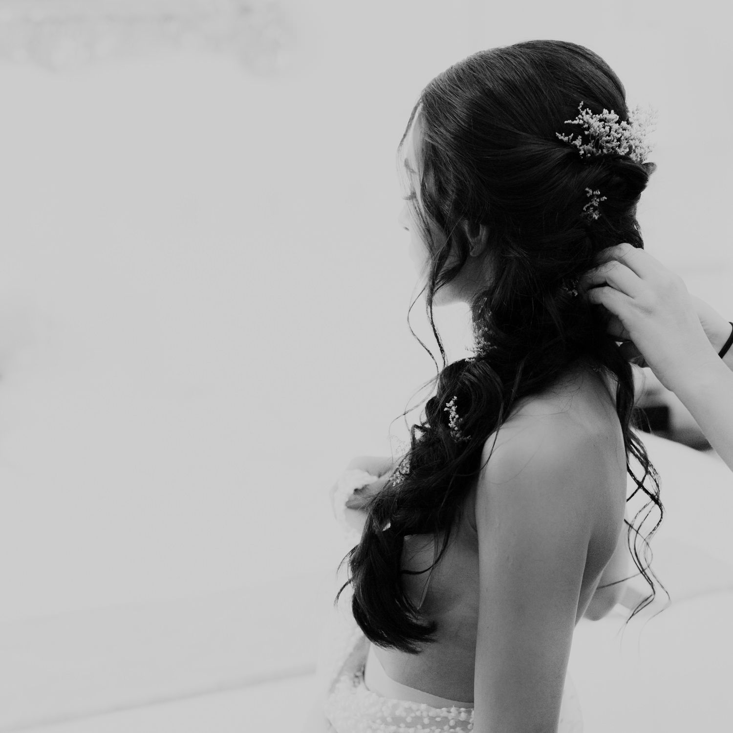 Side profile of an elegant bridal hairstyle with floral hair accessory.