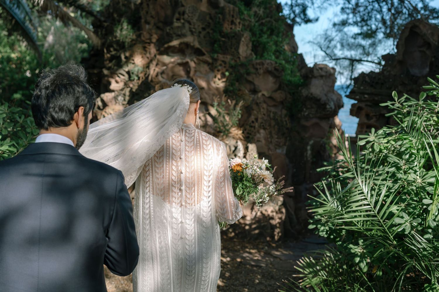 Sunlit garden path with lace dress details and natural greenery.