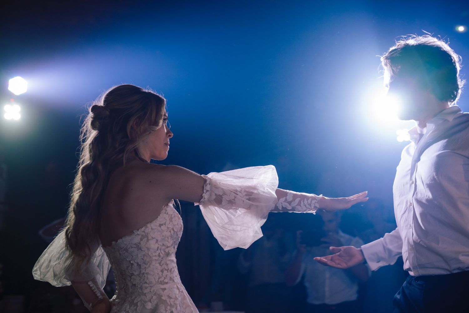 Dramatic backlit silhouettes dancing against a deep blue background.