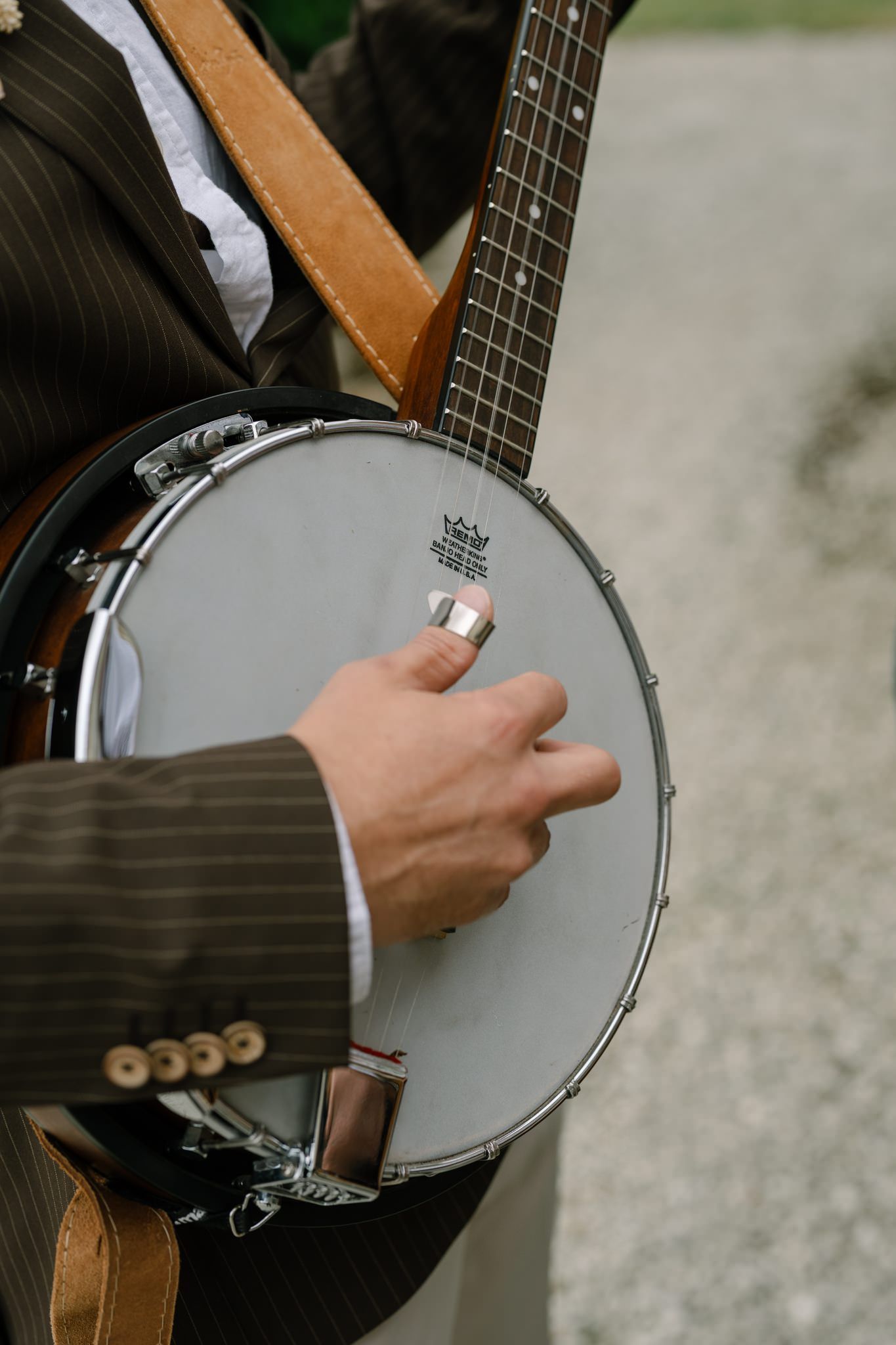Close-up shots of hands playing a banjo with silver hardware.