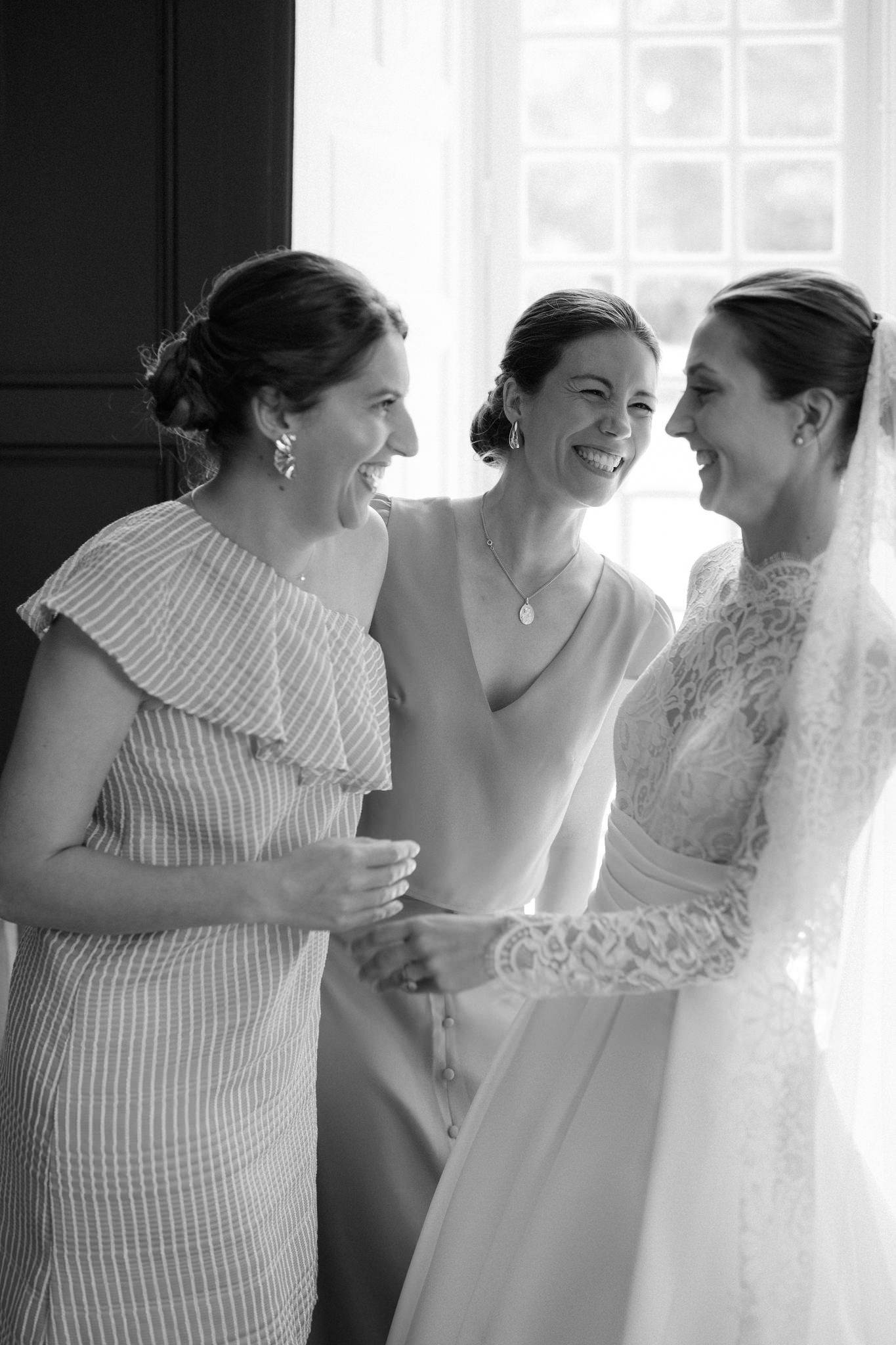 Joyful candid moments during wedding preparations with people laughing together.