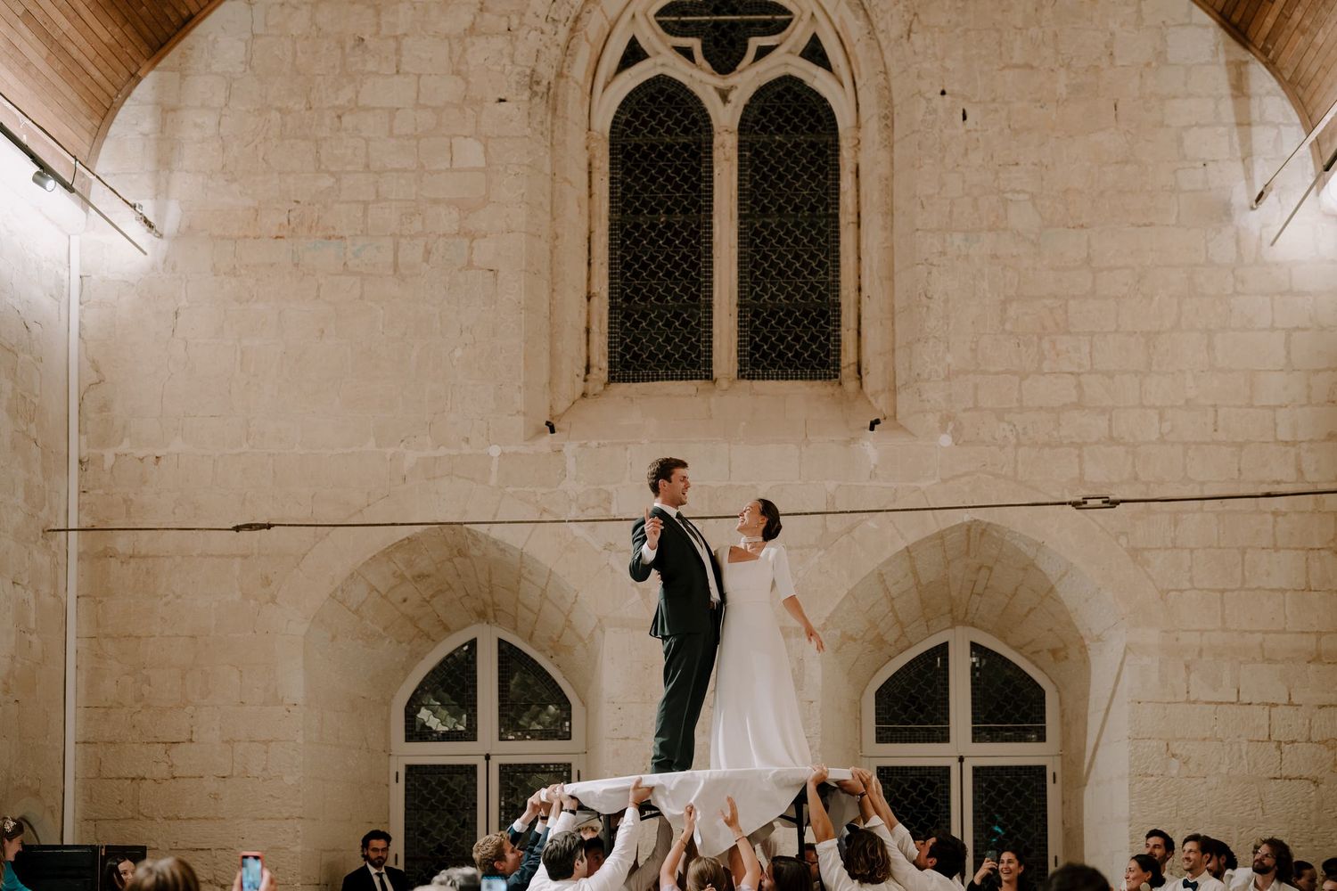 Wedding celebration inside a historic stone church with vaulted ceilings and gothic windows.