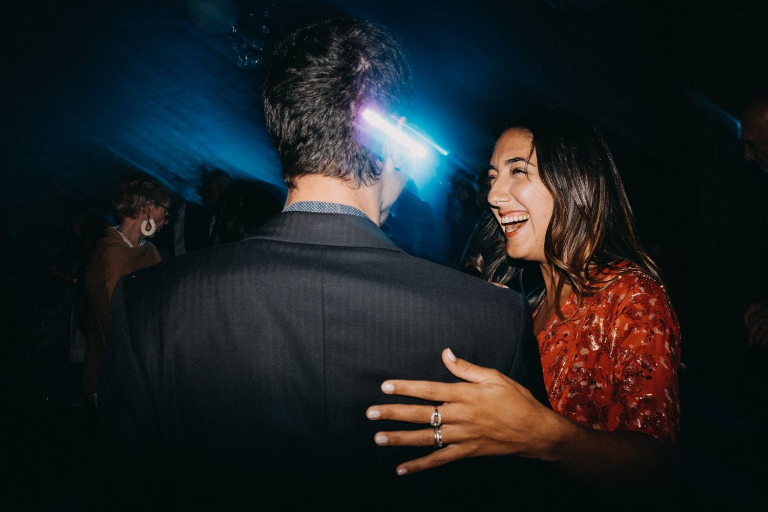 Wedding reception dance floor with blue lighting and guests celebrating.