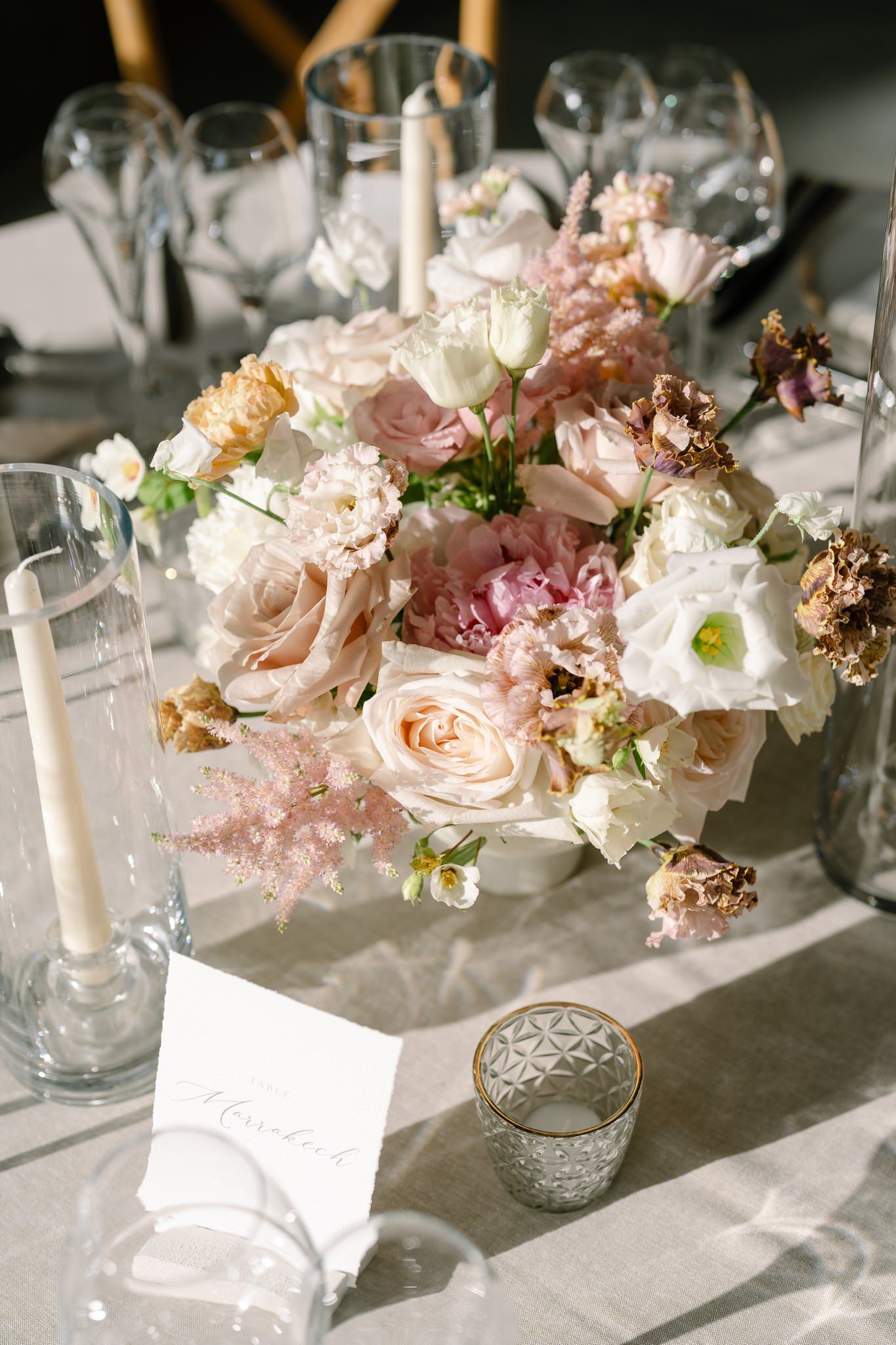 Romantic floral centerpiece featuring blush pink and white roses with delicate candlelight.