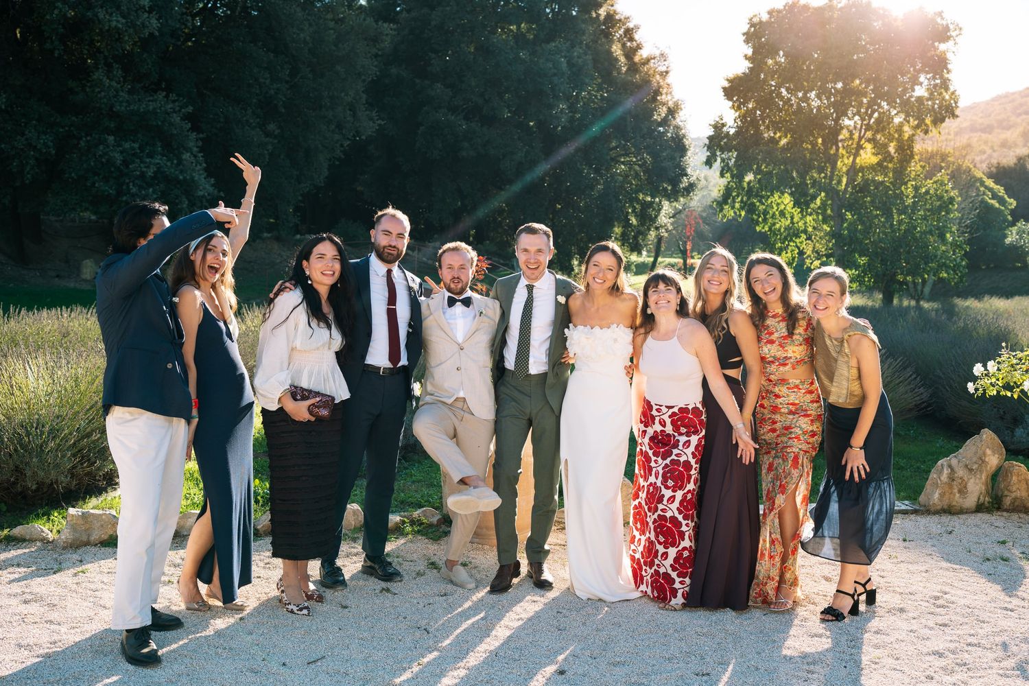 Wedding party poses together outdoors at sunset celebration.