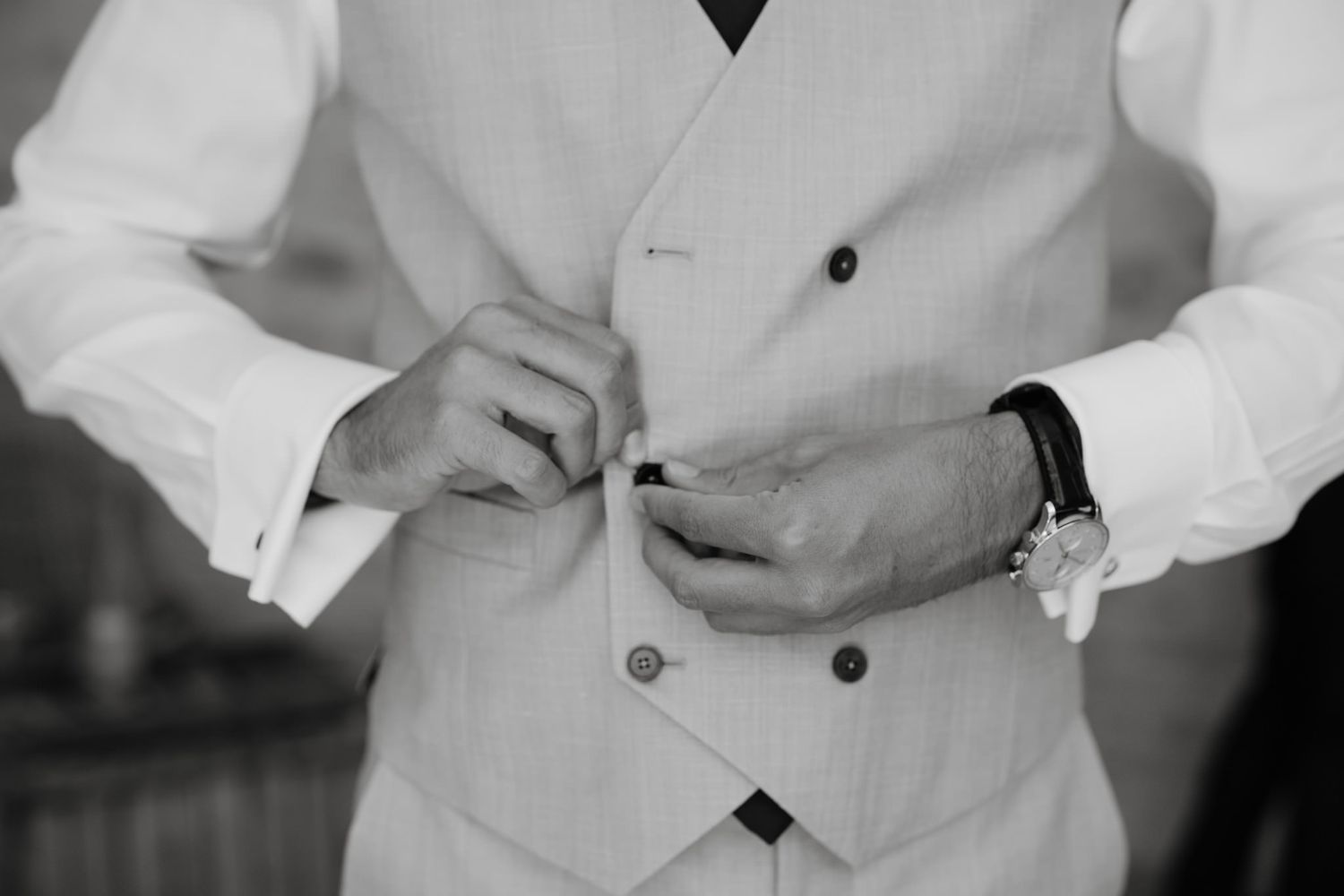People in formal attire adjusting clothing and preparing for event.