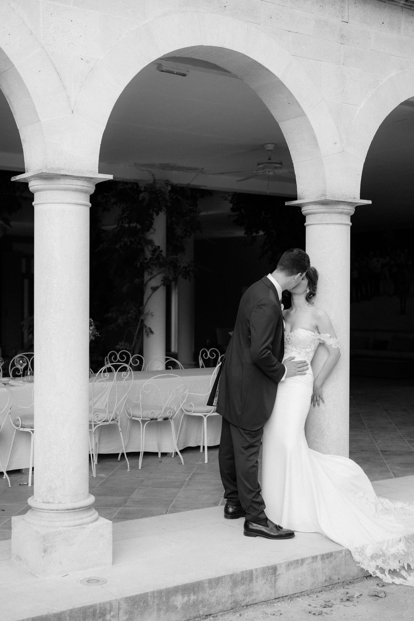 Black and white wedding photos under elegant stone archways and columns.