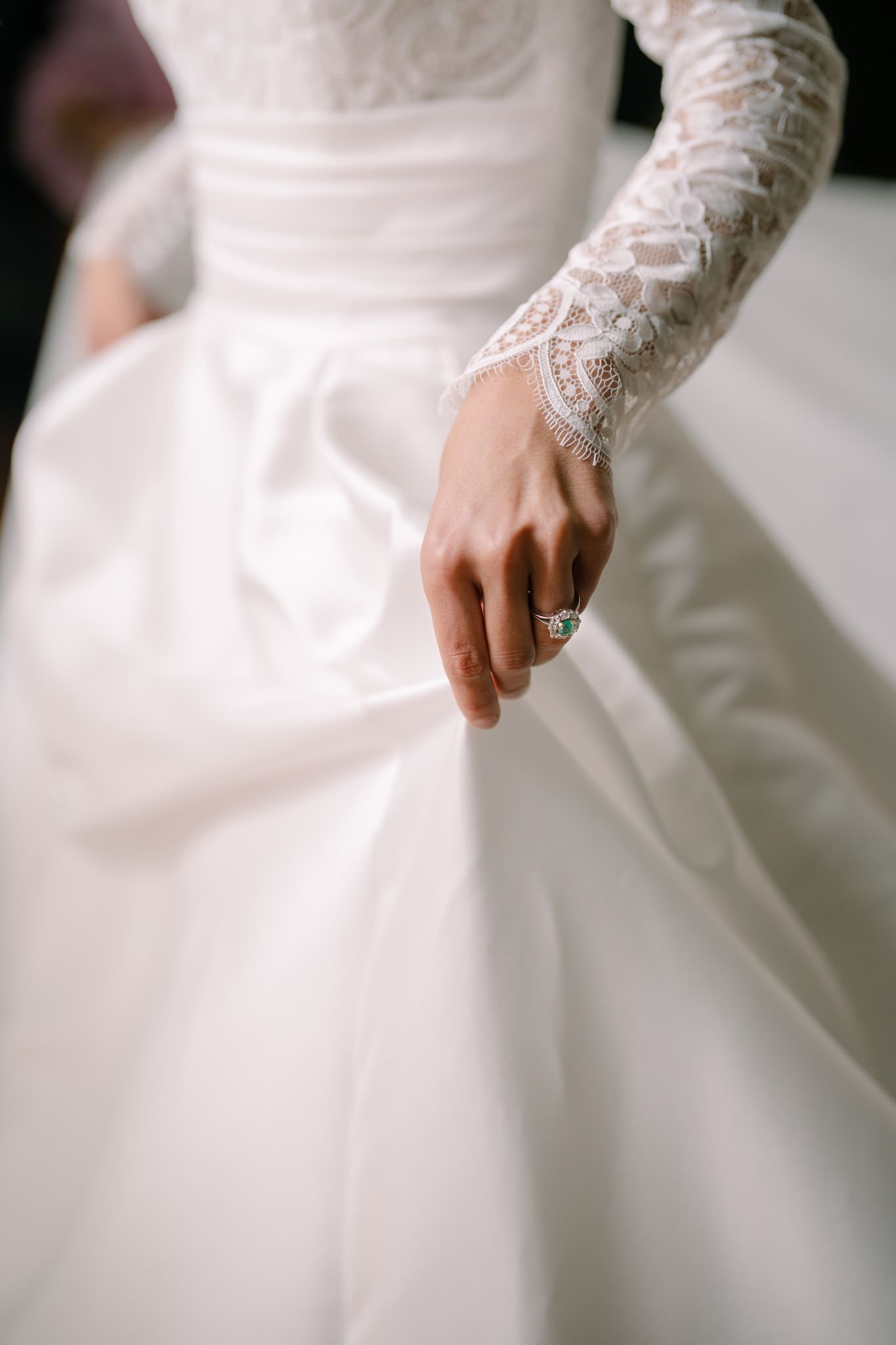 Close-up of delicate lace sleeves and fabric details on a white wedding gown.