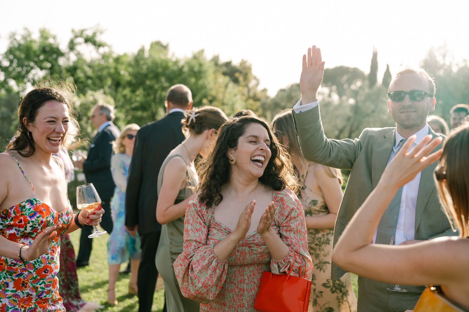 Wedding guests dancing and celebrating during an outdoor summer reception.