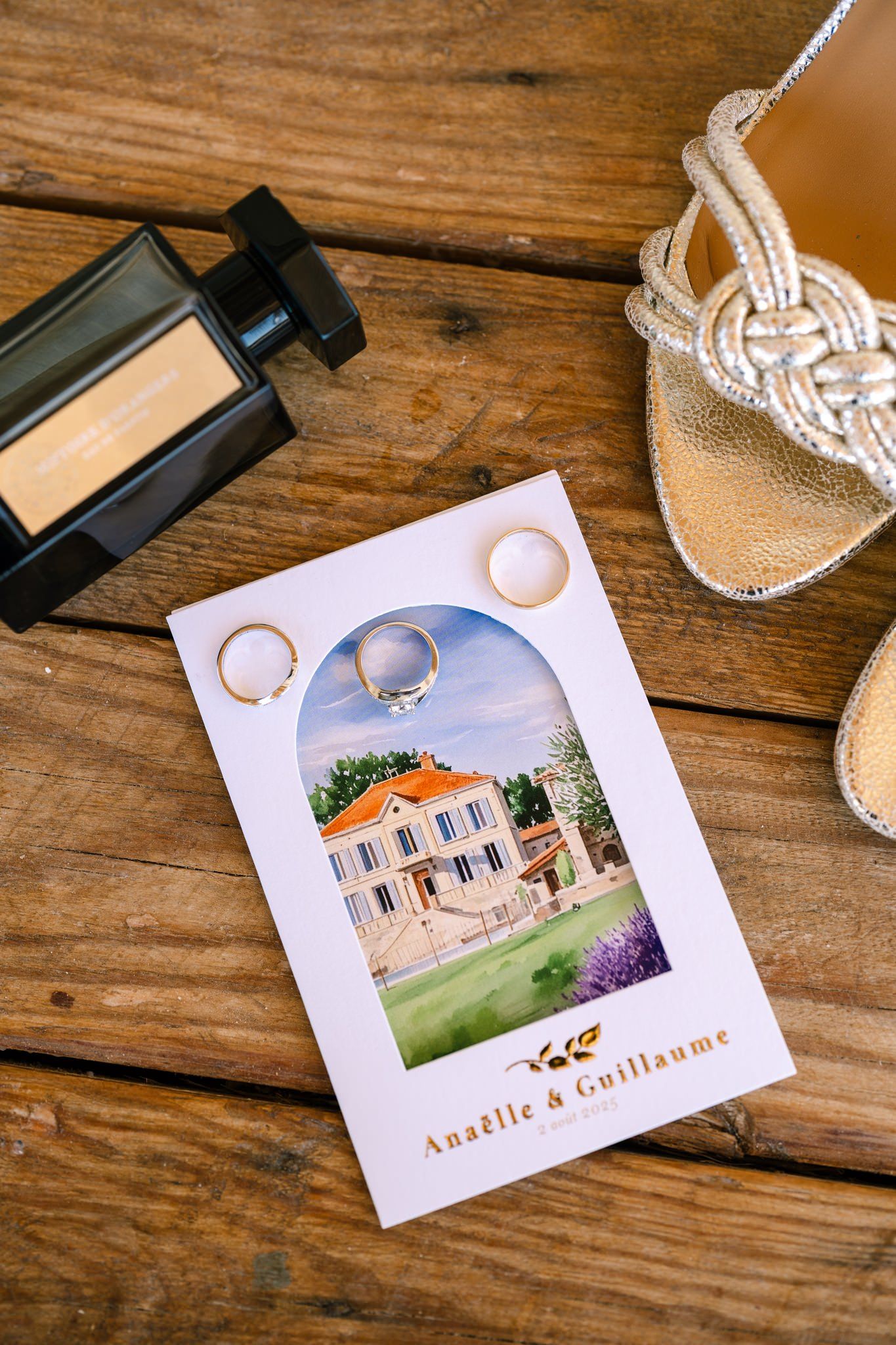 Wedding invitation cards and details displayed on a rustic wooden surface.