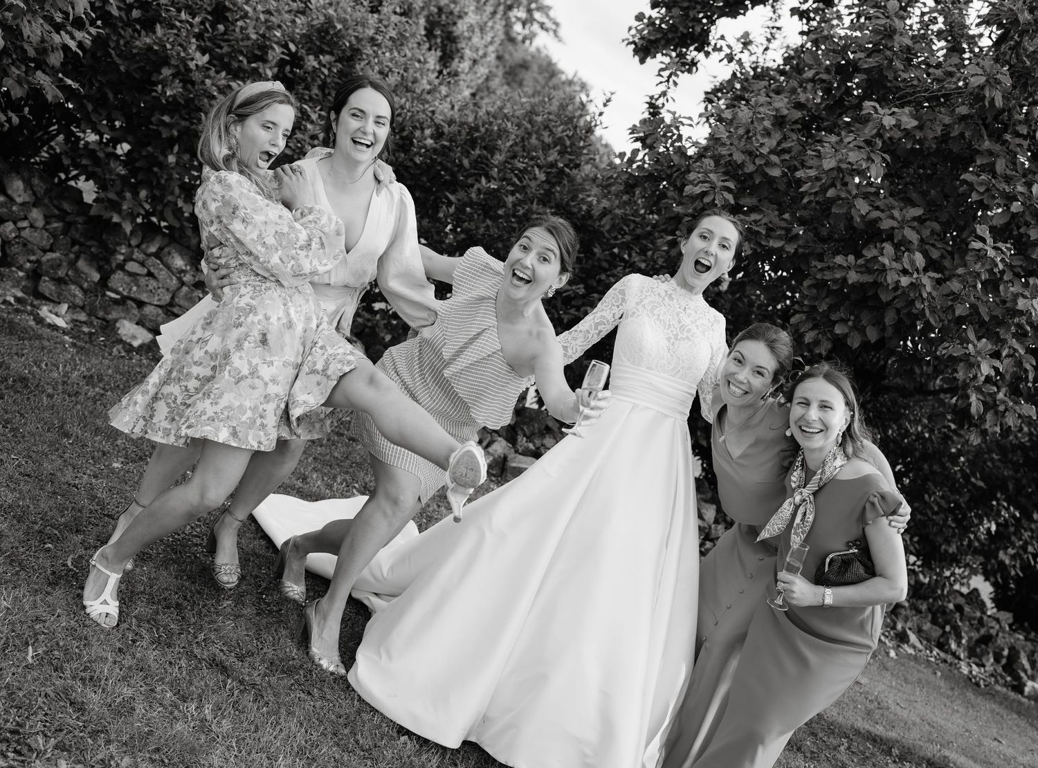 Black and white photos showing playful moments at an outdoor wedding celebration.