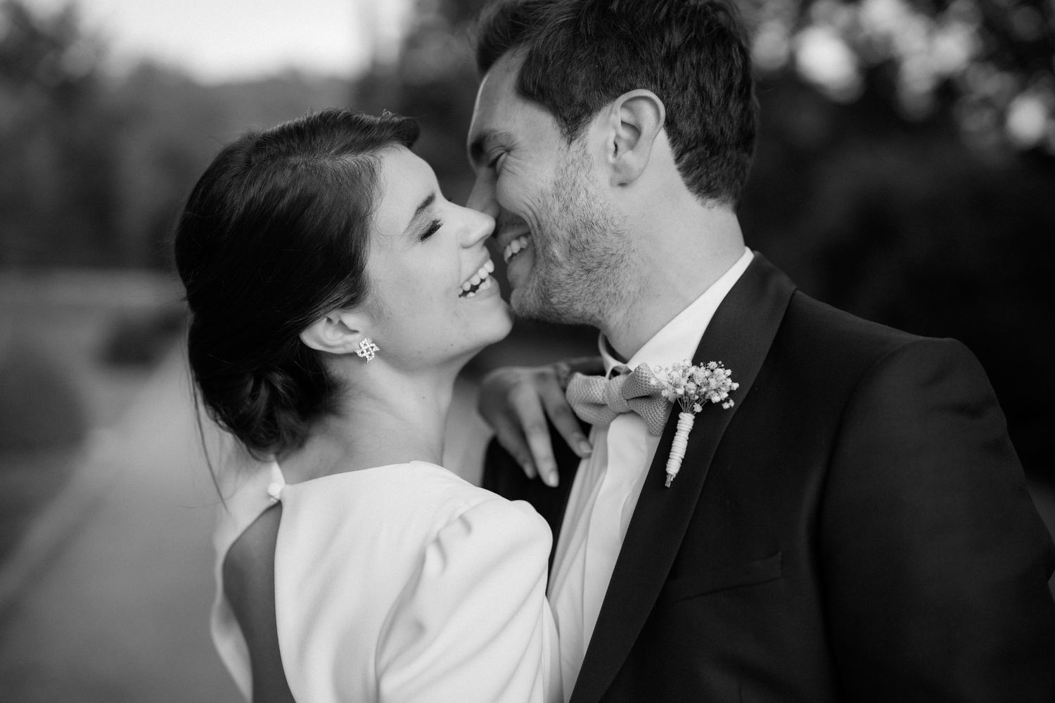 An intimate black and white portrait of newlyweds sharing a tender moment.