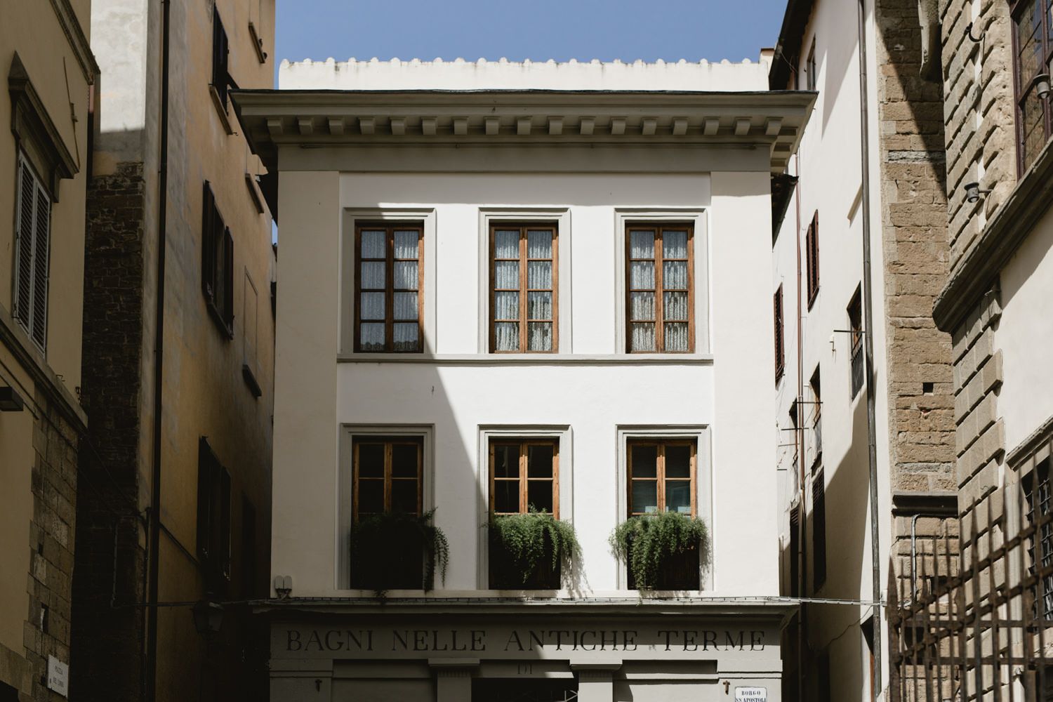 Elegant white stone courtyard with classic European architectural details and windows.