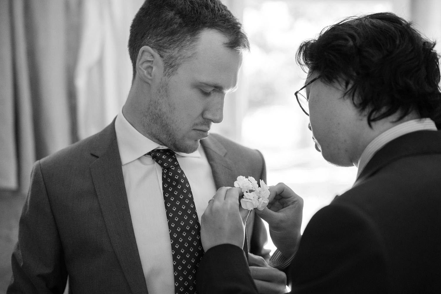 Groomsmen in dark suits and polka dot ties getting ready before a wedding ceremony.