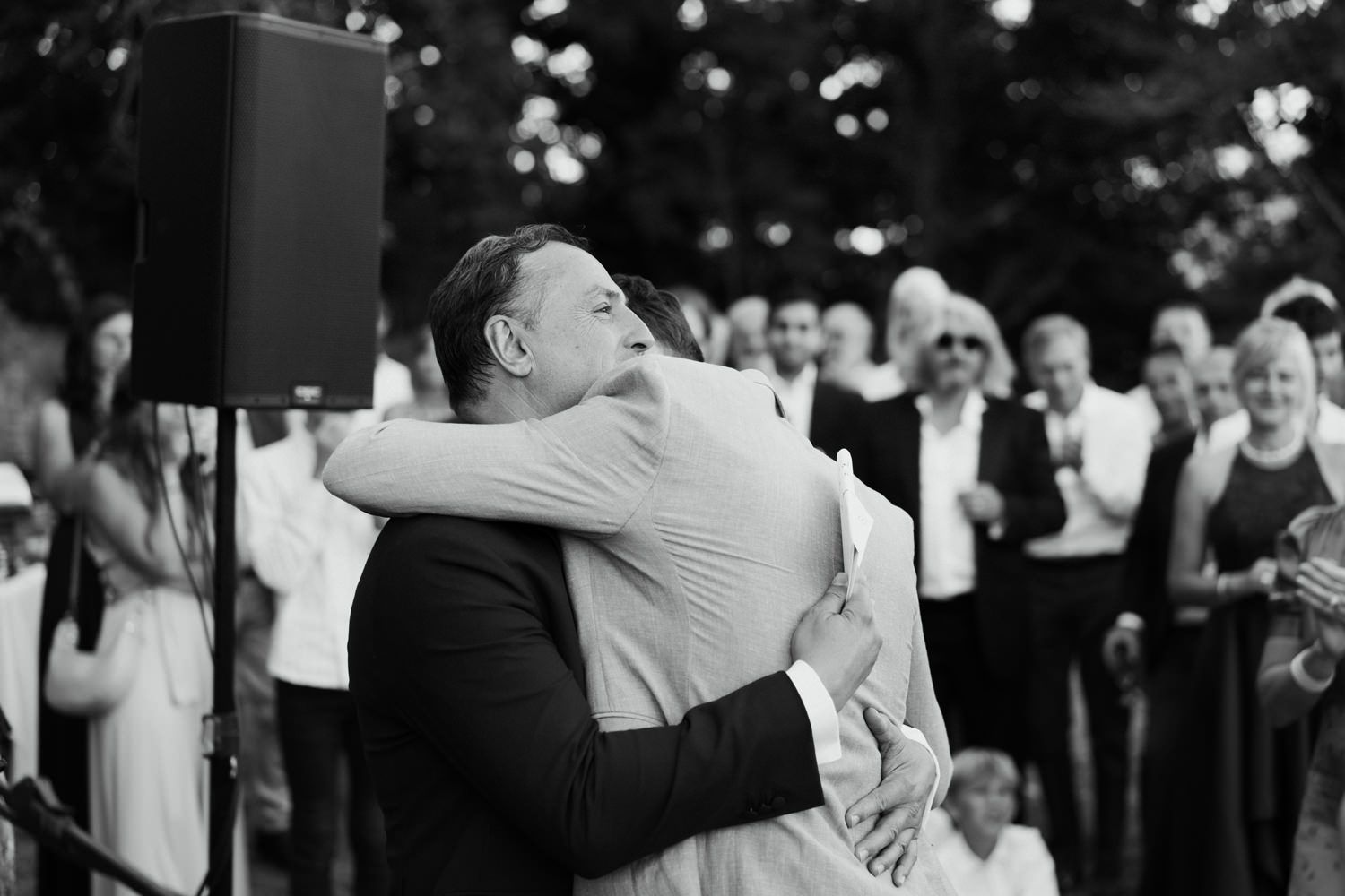 Wedding guests dancing and celebrating joyfully at an outdoor reception.