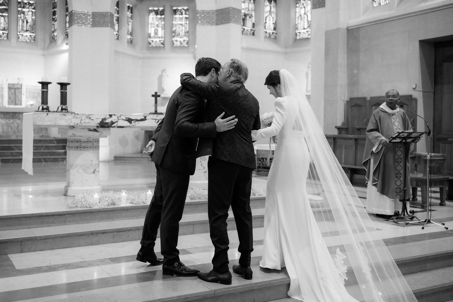 Intimate moment during church wedding ceremony with flowing white veil.