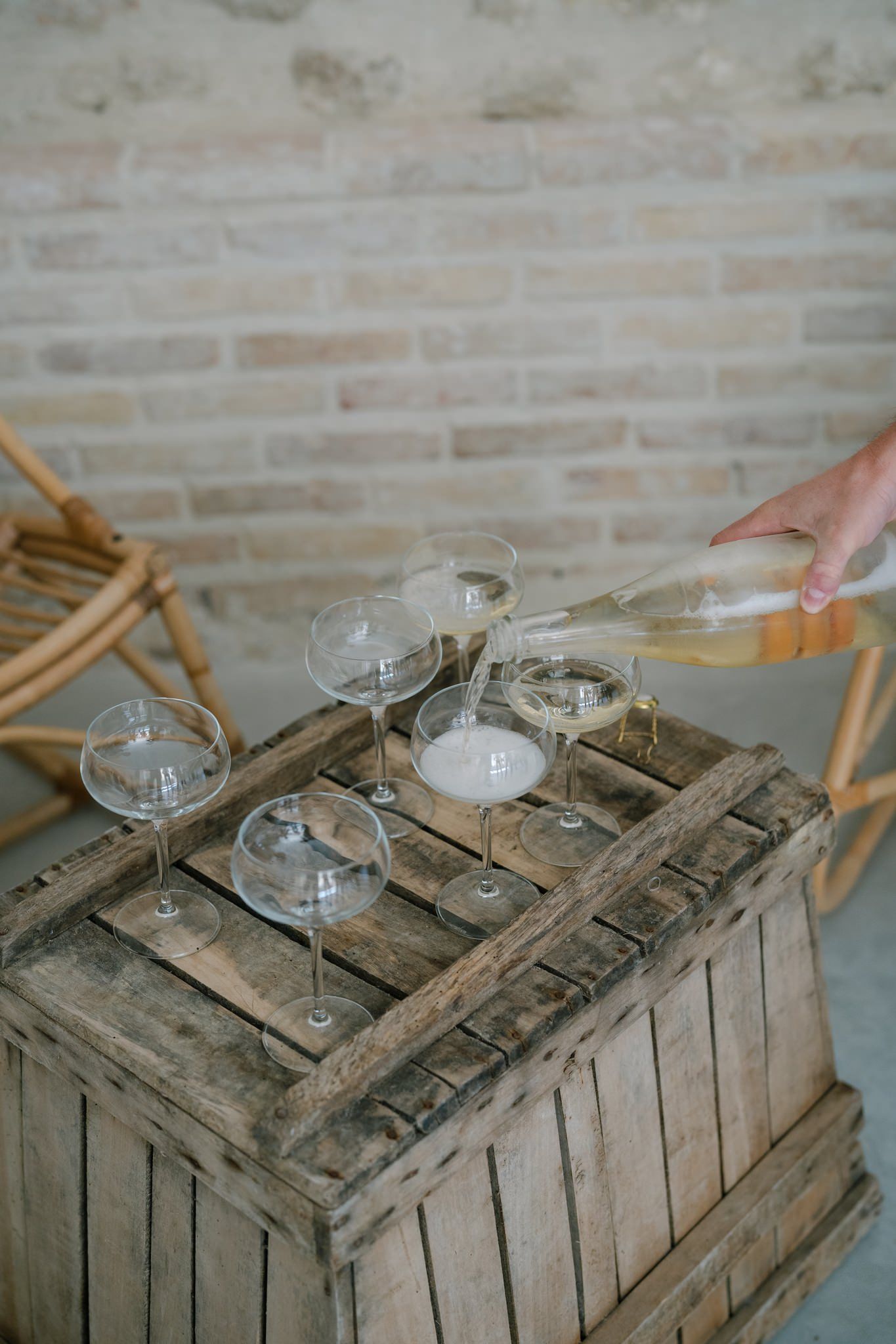 Champagne glasses being arranged on vintage wooden crate surface.