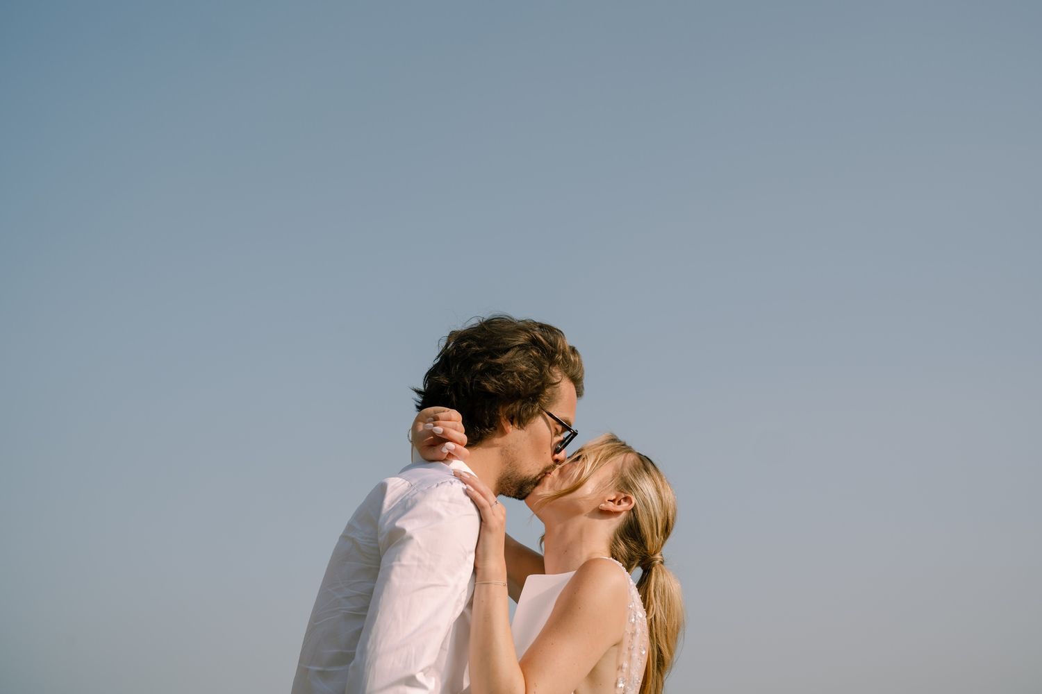 Couple sharing intimate moment against scenic mountain backdrop.