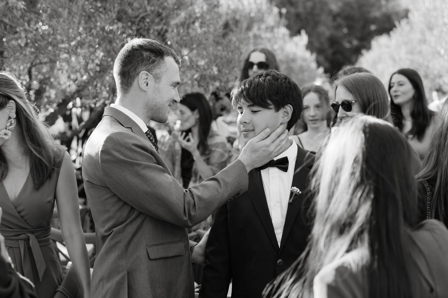 Wedding guests gathered outdoors in formal attire at a celebration.