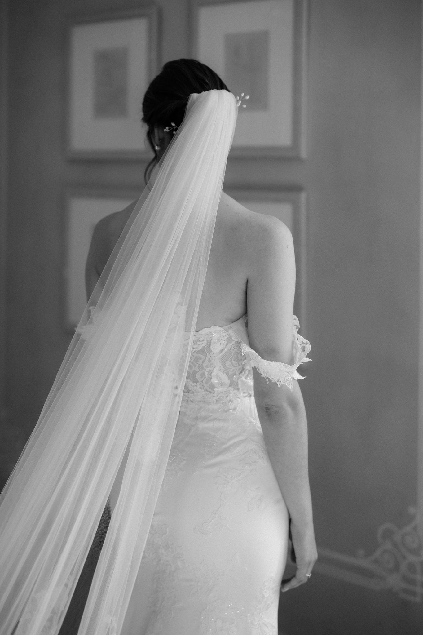 Close-up details of a white wedding dress and flowing veil in black and white.