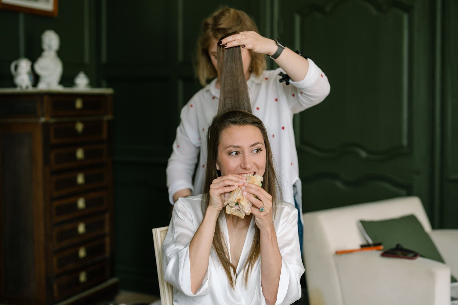 Bride getting ready in an elegant room with vintage furniture and natural lighting.