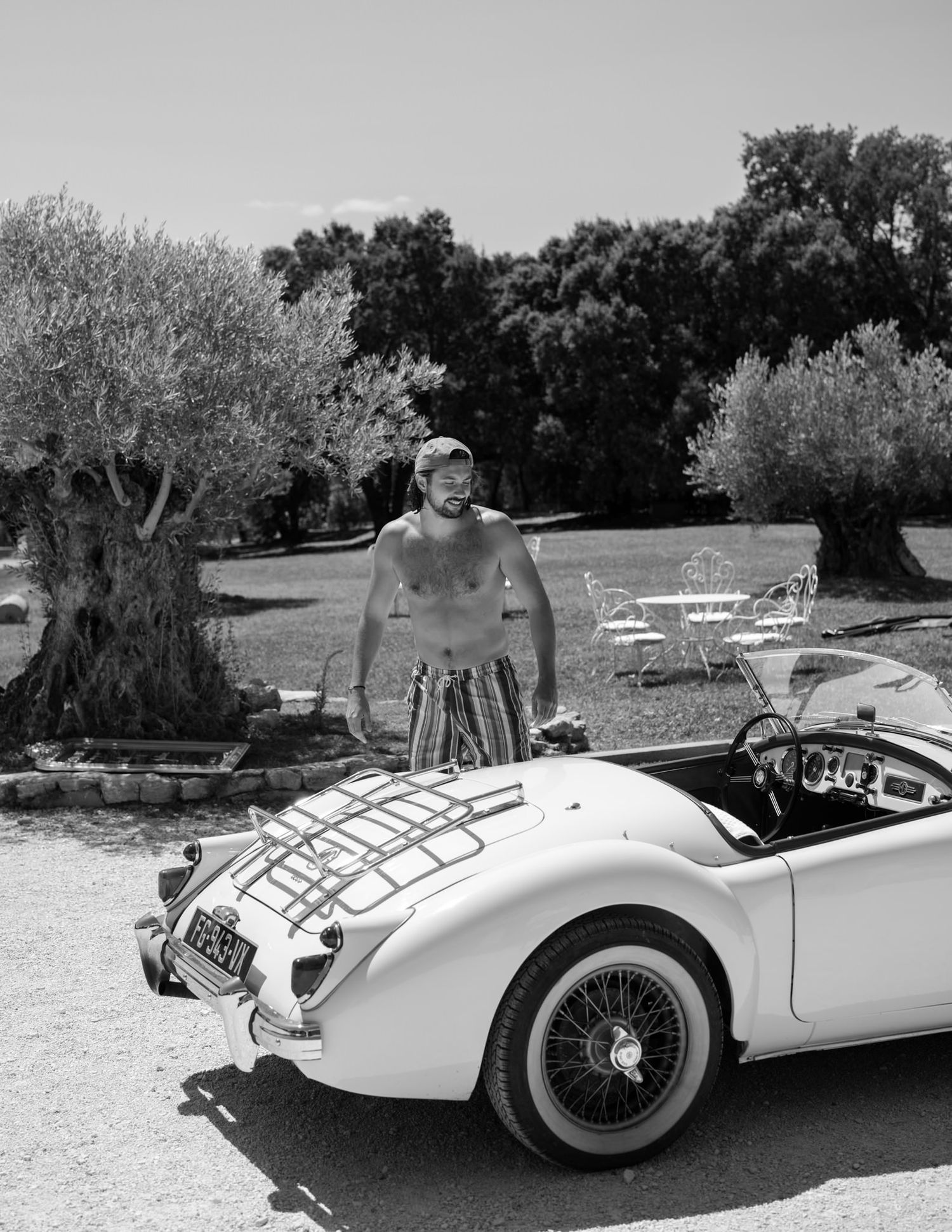 Vintage white convertible sports car photographed from multiple angles against a natural backdrop.