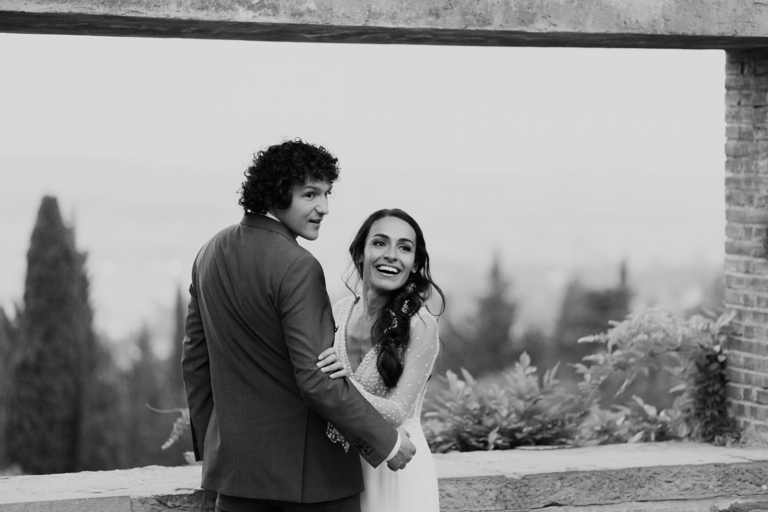 Black and white portrait of couple sharing joyful moment on terrace.