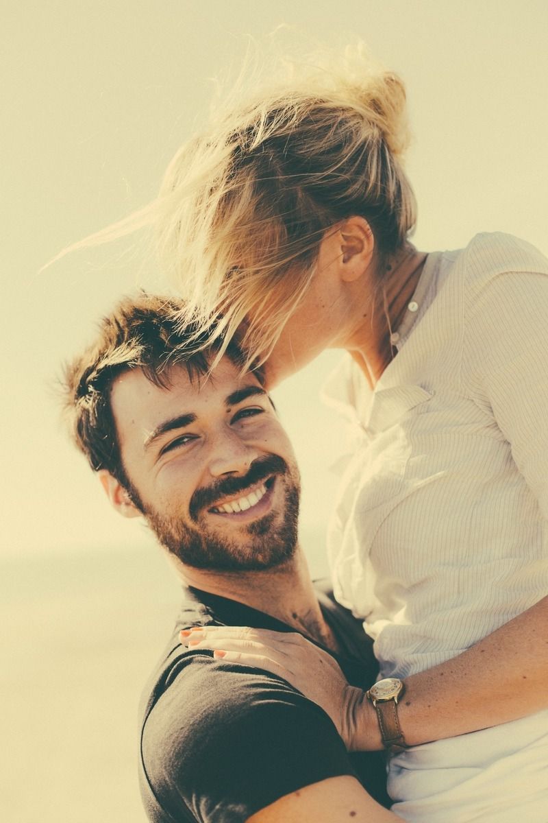 Candid romantic moments captured in warm sunlit photography.