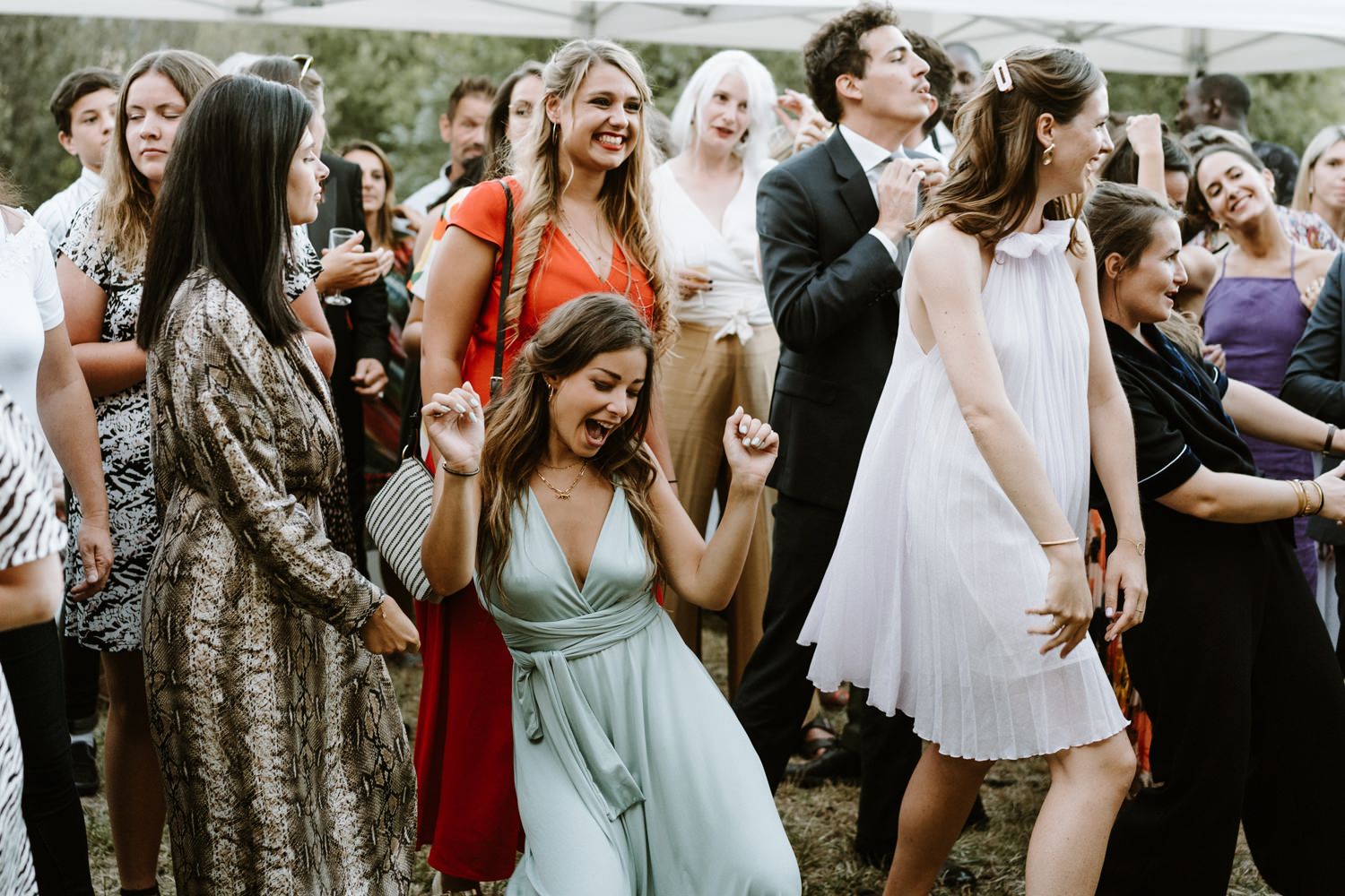 Wedding guests mingling and socializing at outdoor celebration.