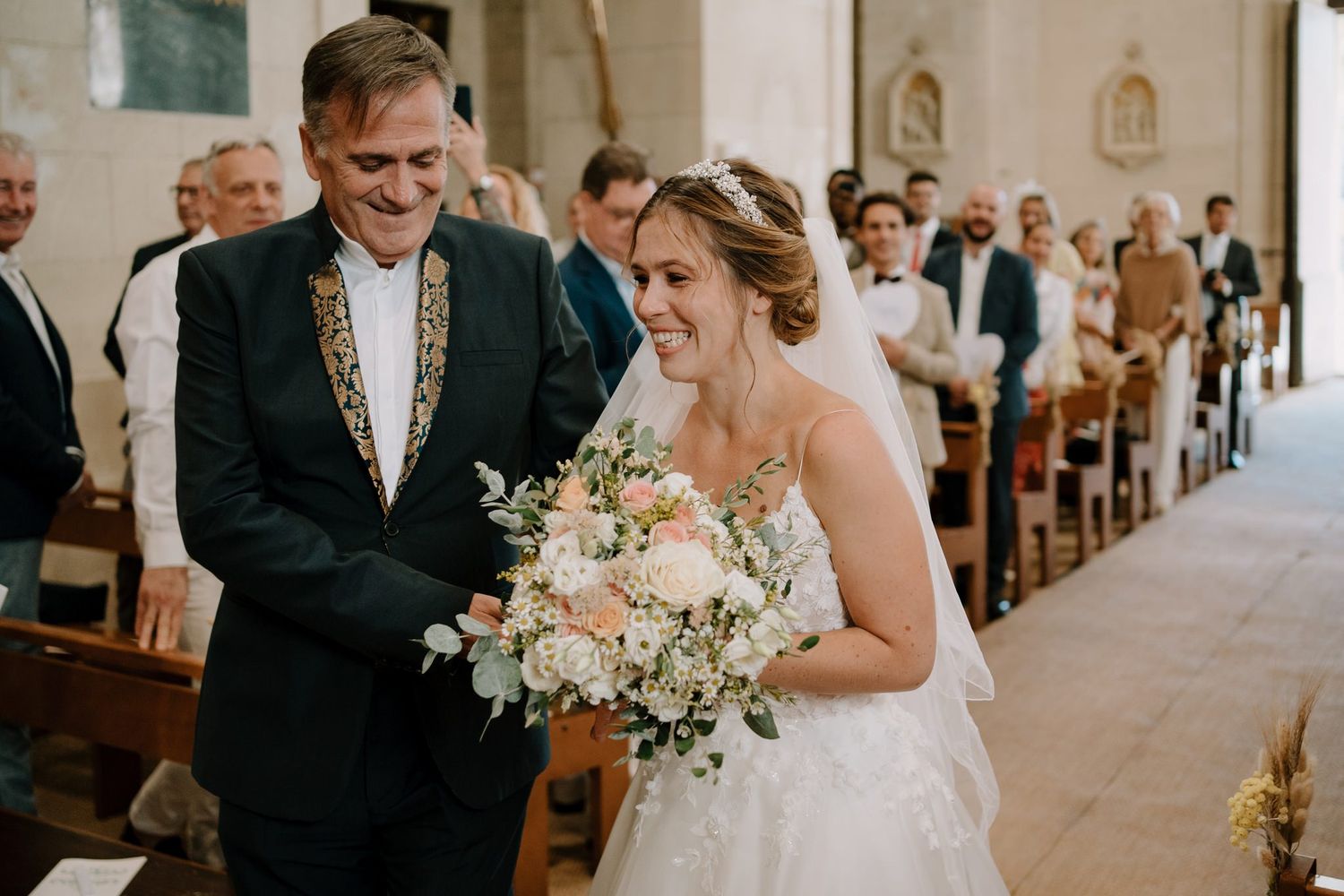 Wedding ceremony in a bright cathedral with elegant floral arrangements and classic architecture.