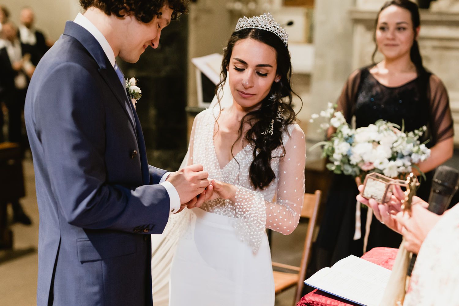 Intimate wedding ceremony moment captured in a historic stone church interior.