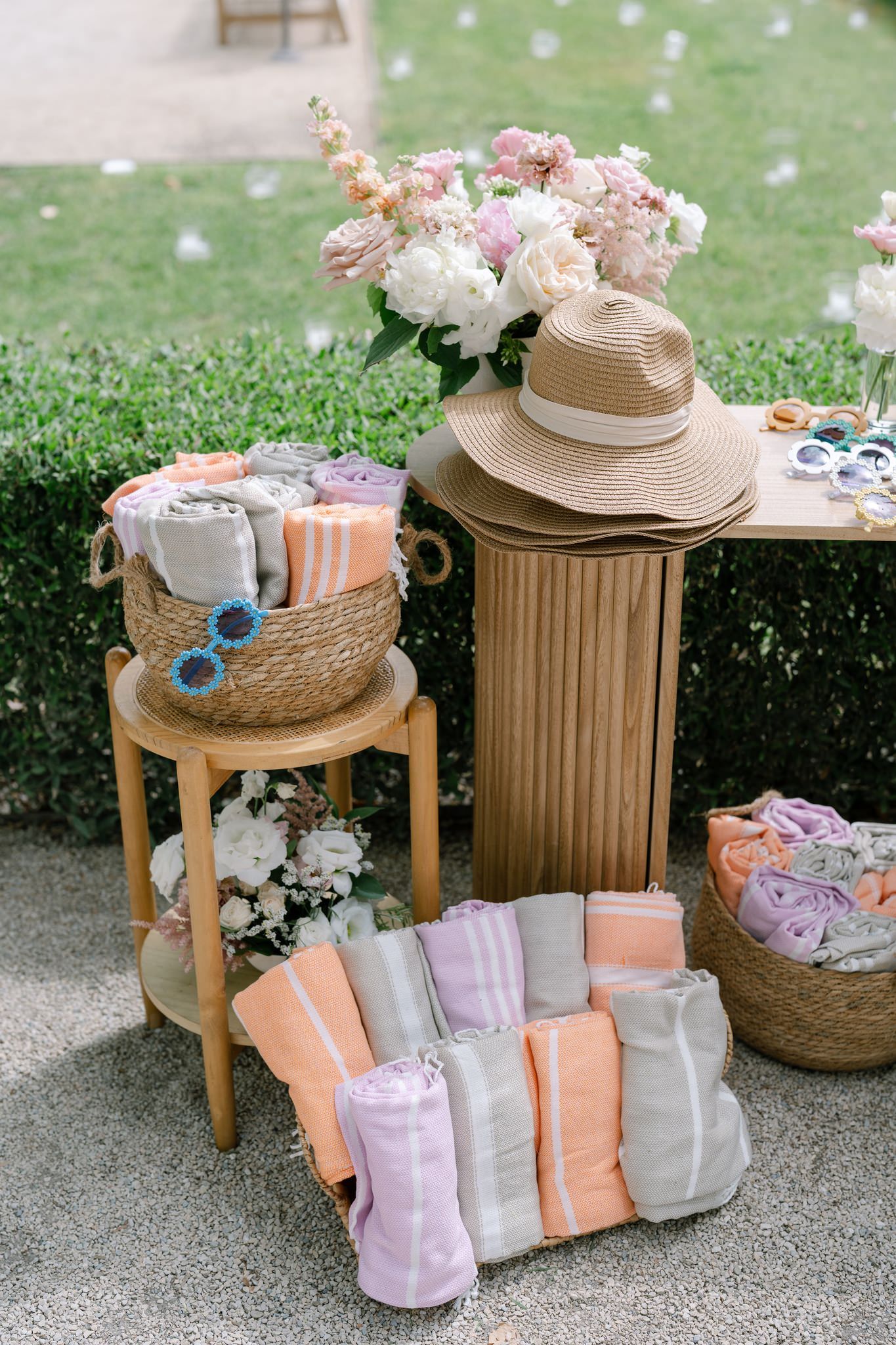 Wedding favors and gift bags arranged with straw hats and floral decorations.