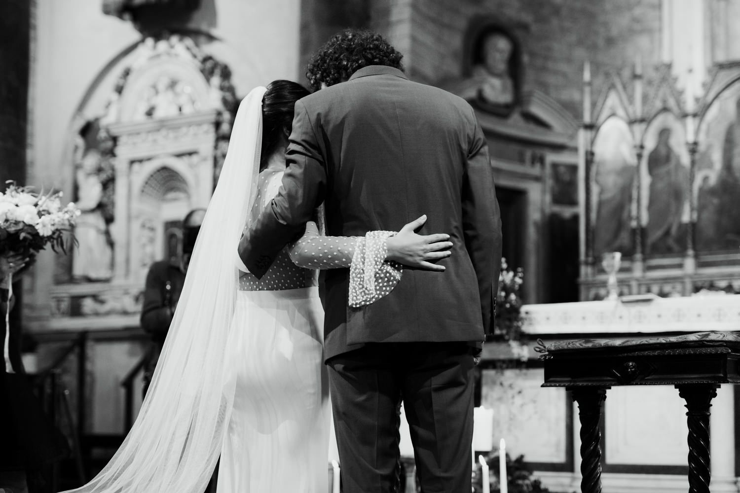 Black and white photograph capturing emotional moments during church wedding ceremony.