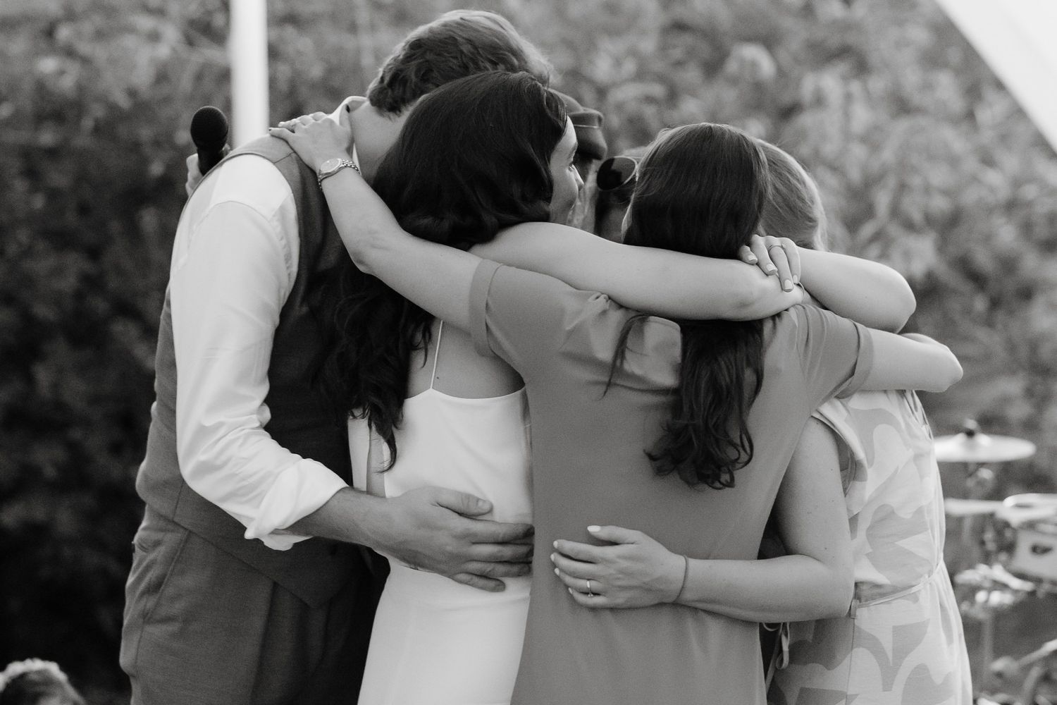 Black and white photo of people hugging in a group.
