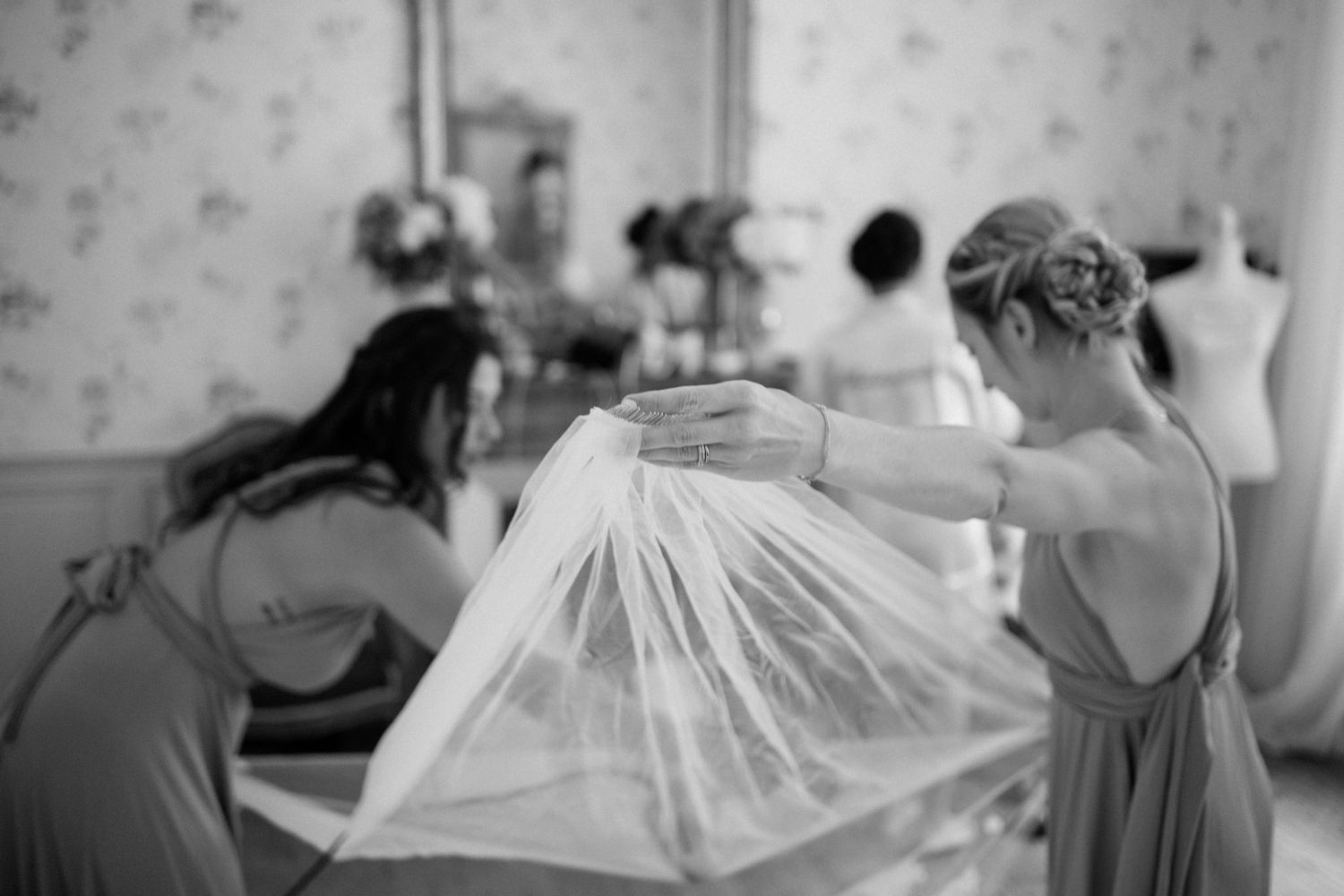 Getting ready scene with bridesmaids in matching robes preparing for wedding day.
