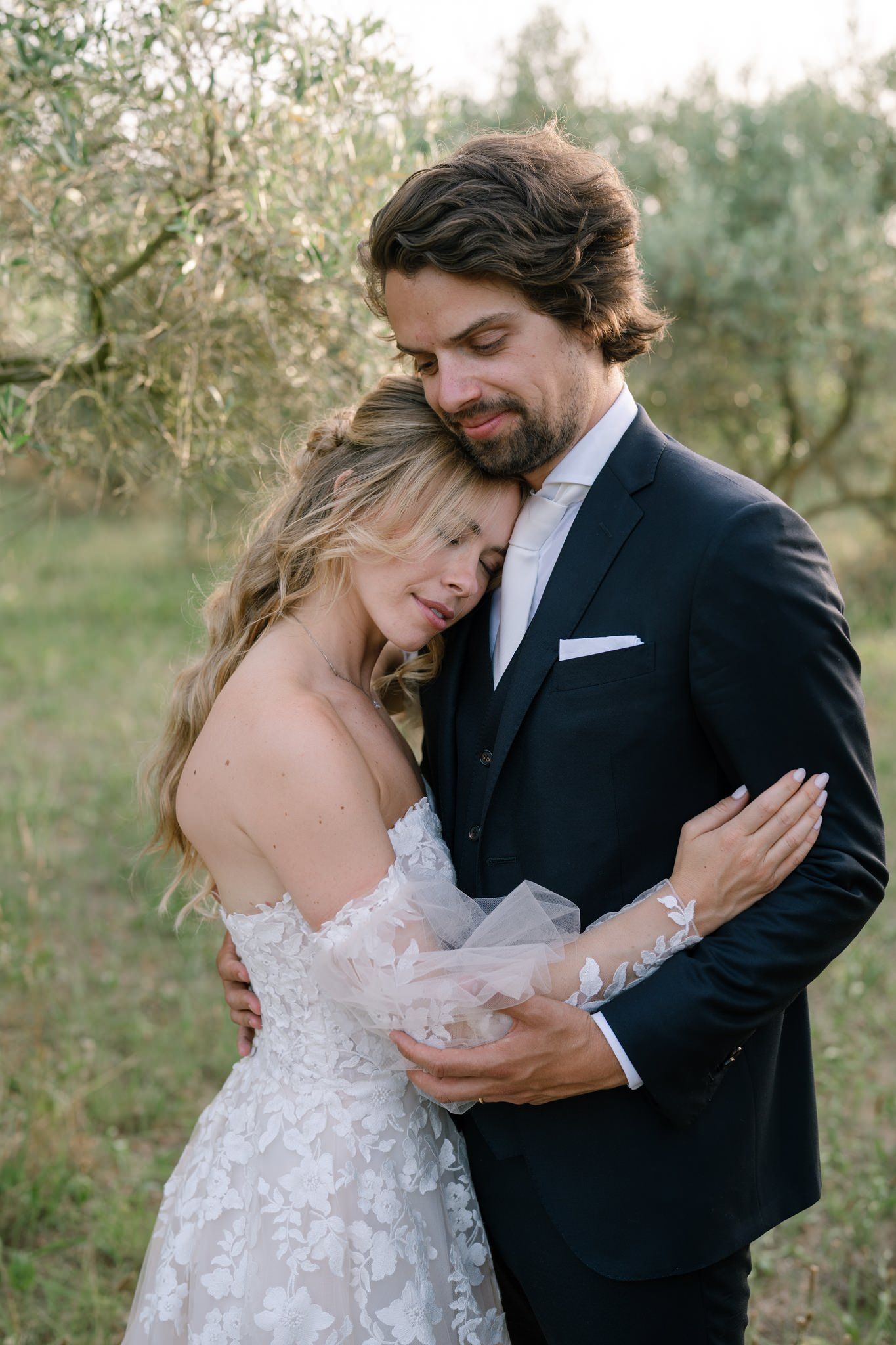 Romantic wedding couple shares intimate moments in an olive grove during golden hour.