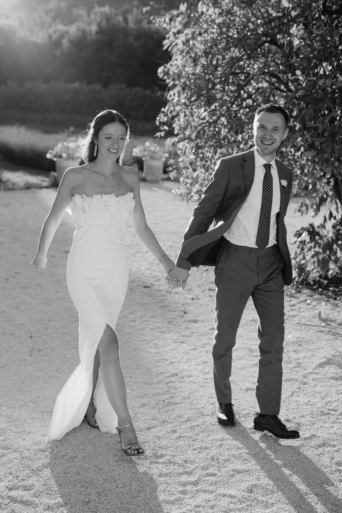 Black and white photos of playful wedding couple dancing outdoors.