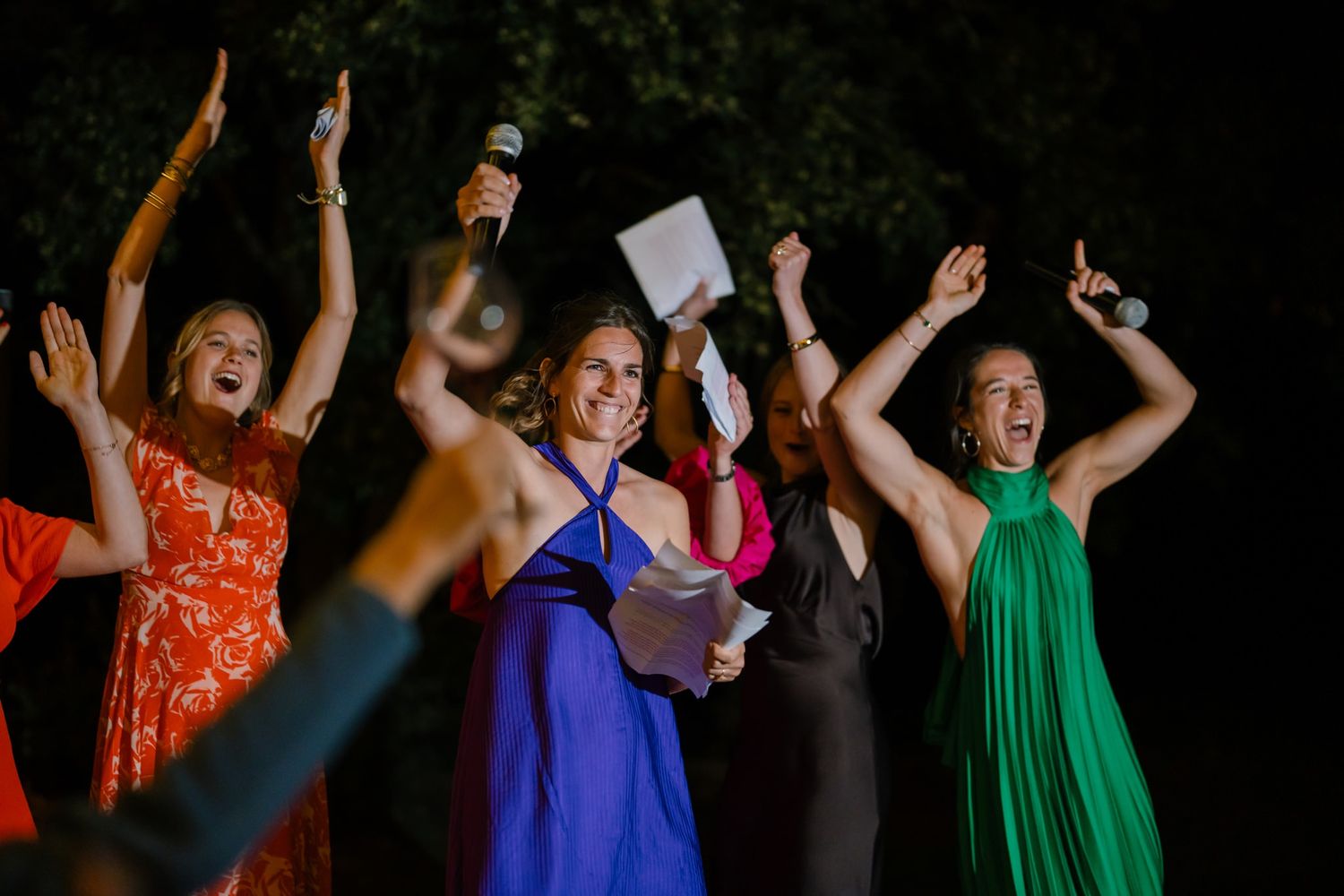 Party guests dancing in colorful dresses during an evening celebration.
