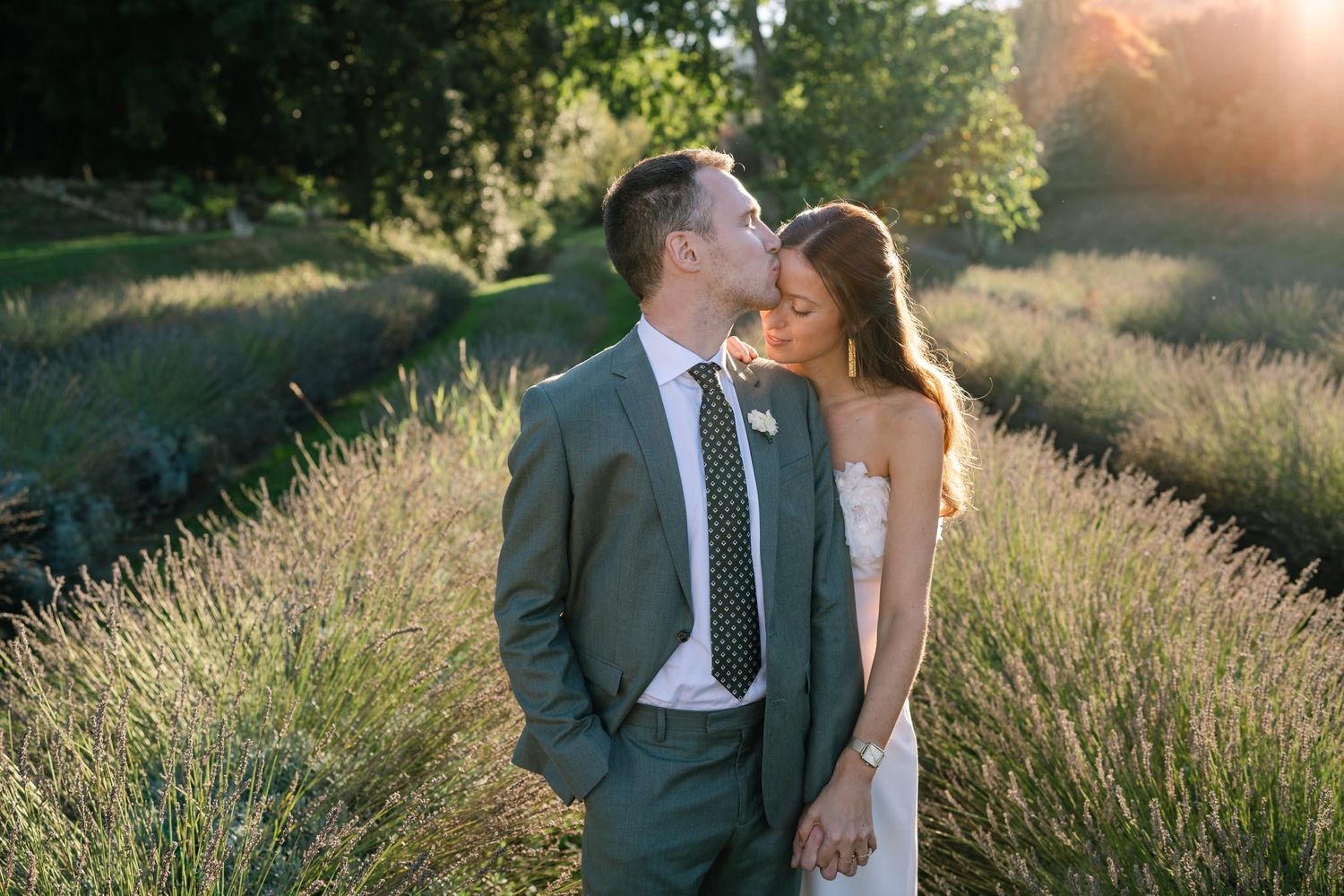 Sunset wedding photoshoot in a field with soft natural lighting and greenery.
