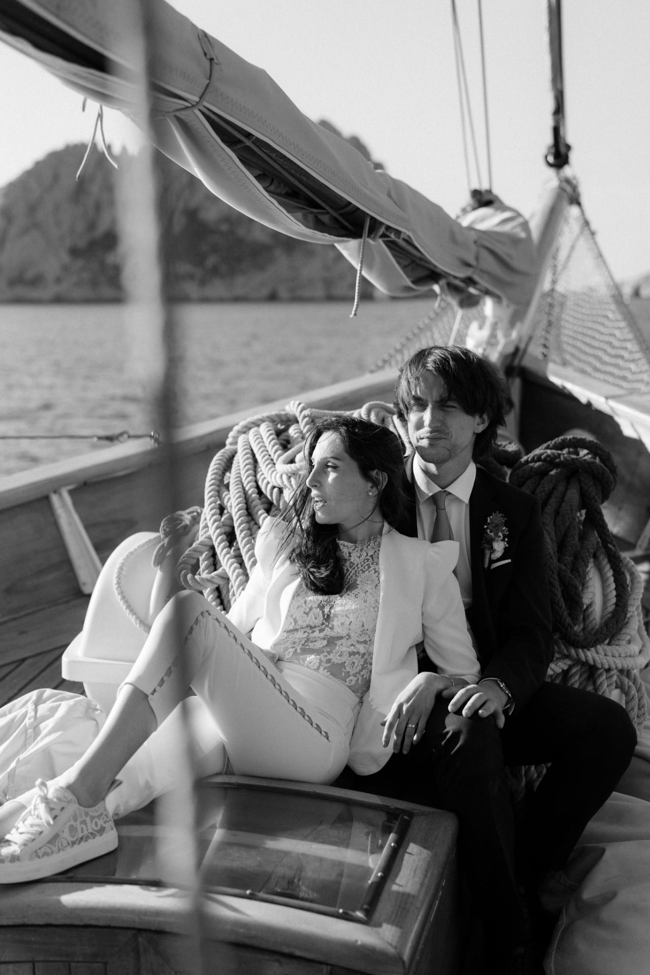 Wedding couple sharing intimate moments on a sailboat deck in black and white.