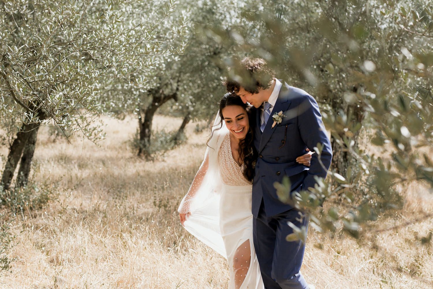 Elegant couple shares tender moments during their wedding photoshoot in an olive grove.